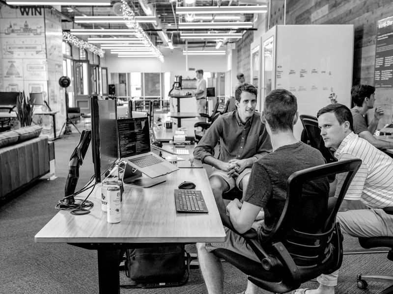 Nova Link Communications team collaborating around desks in a bright open office