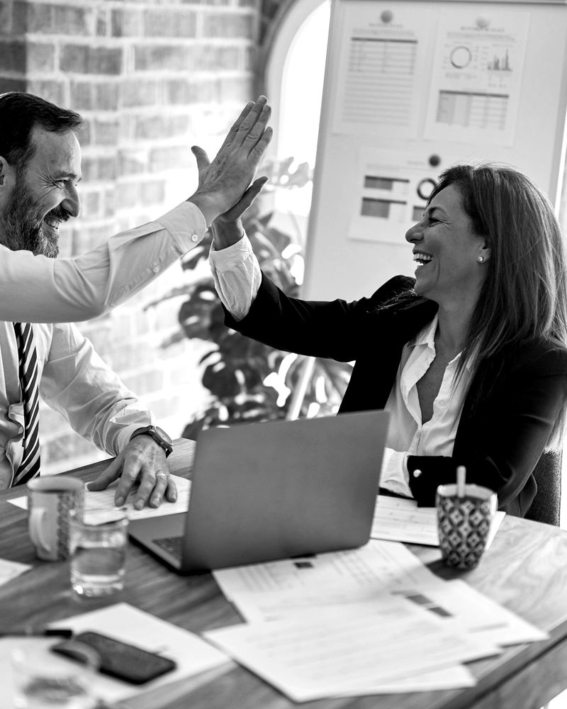 Two Nova Link Communications sales team members celebrating a win with a high five at the office