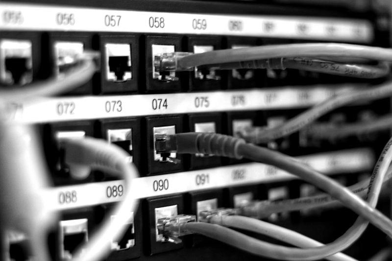 Numbered network patch panel with ethernet cables plugged in, representing high-speed internet service